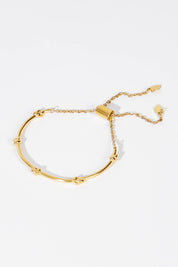 A model wearing size OneSize of the Knots Of Freedom Bracelet in colour Gold (Metallics), from the front, showing the whole outfit