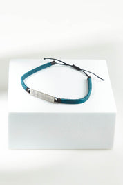 A model wearing the Light Triumphs Over Darkness Vegan Leather Bracelet in colour Blue (Blue), from the front, showing the whole outfit