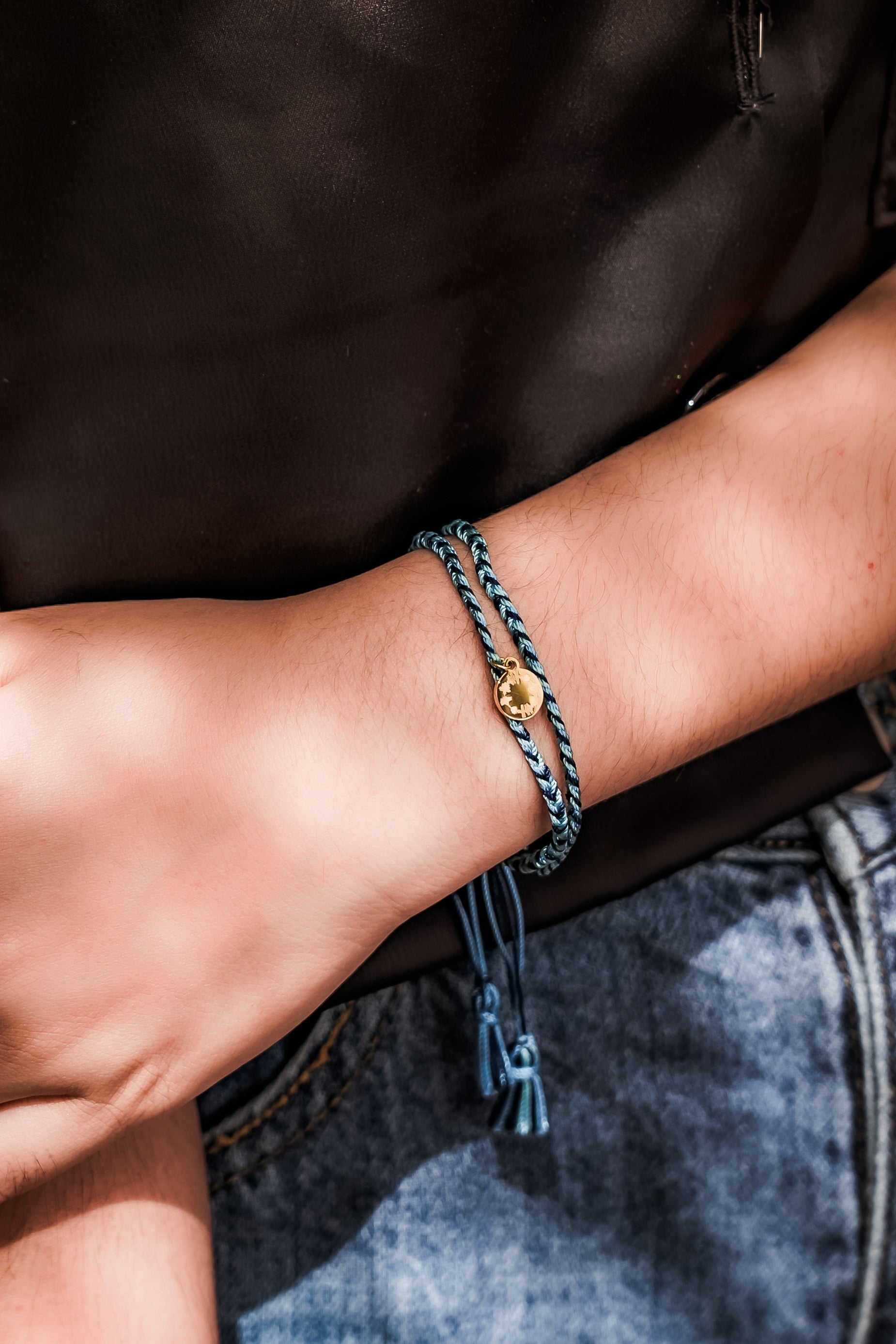 A model wearing the Light Triumphs Over Darkness Woven Bracelet in colour Blue (Blue), from the front, showing the whole outfit