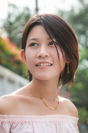 A model wearing the Desert Wild Flower Earrings in colour Gold (Metallics), from the front, showing the whole outfit