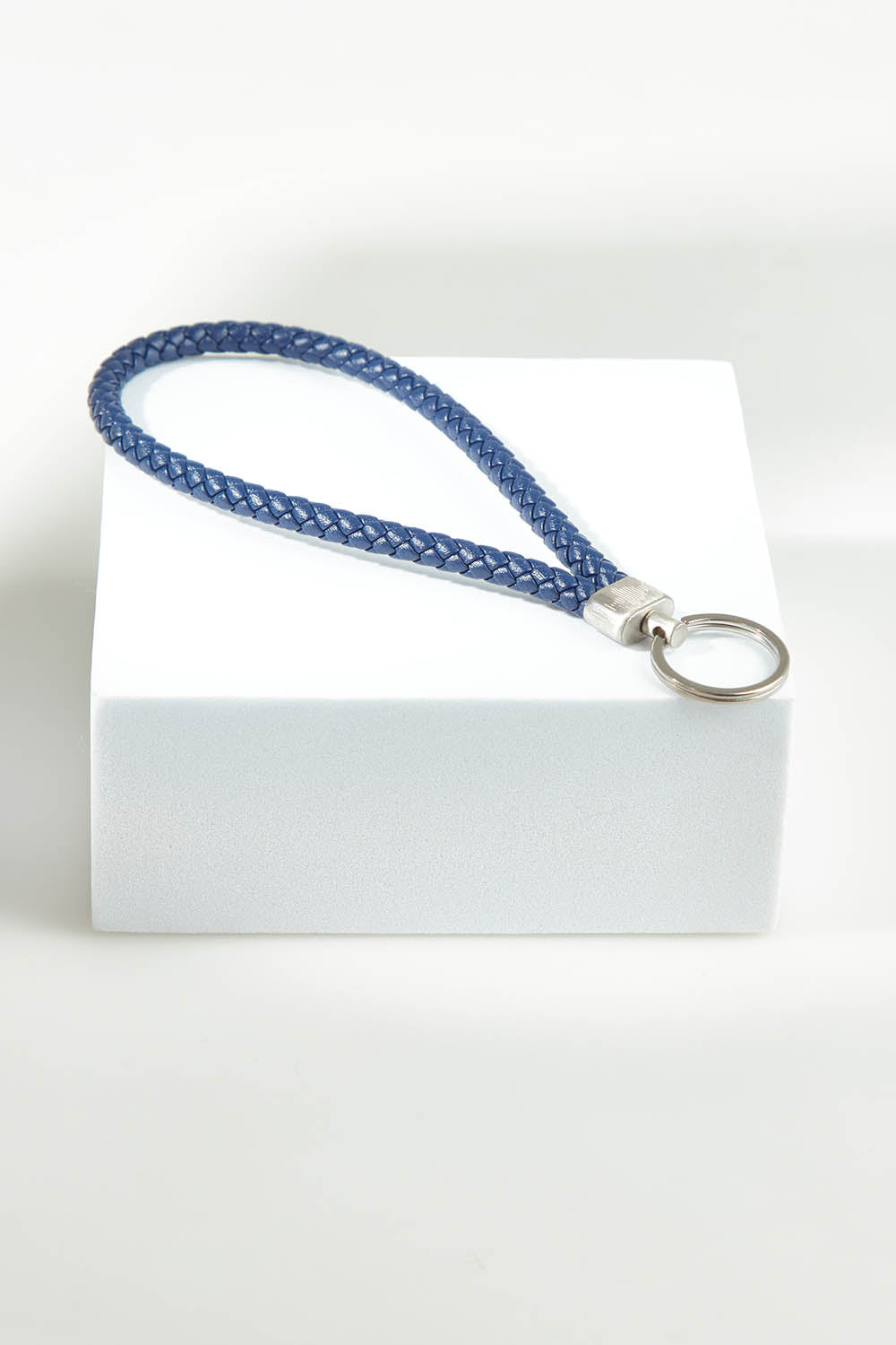 A model wearing the Light Triumphs Over Darkness Leather Keyring in colour Blue (Blue), from the front, showing the whole outfit