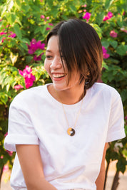 A model wearing the Committed Necklace in colour Gold (Metallics), from the front, showing the whole outfit