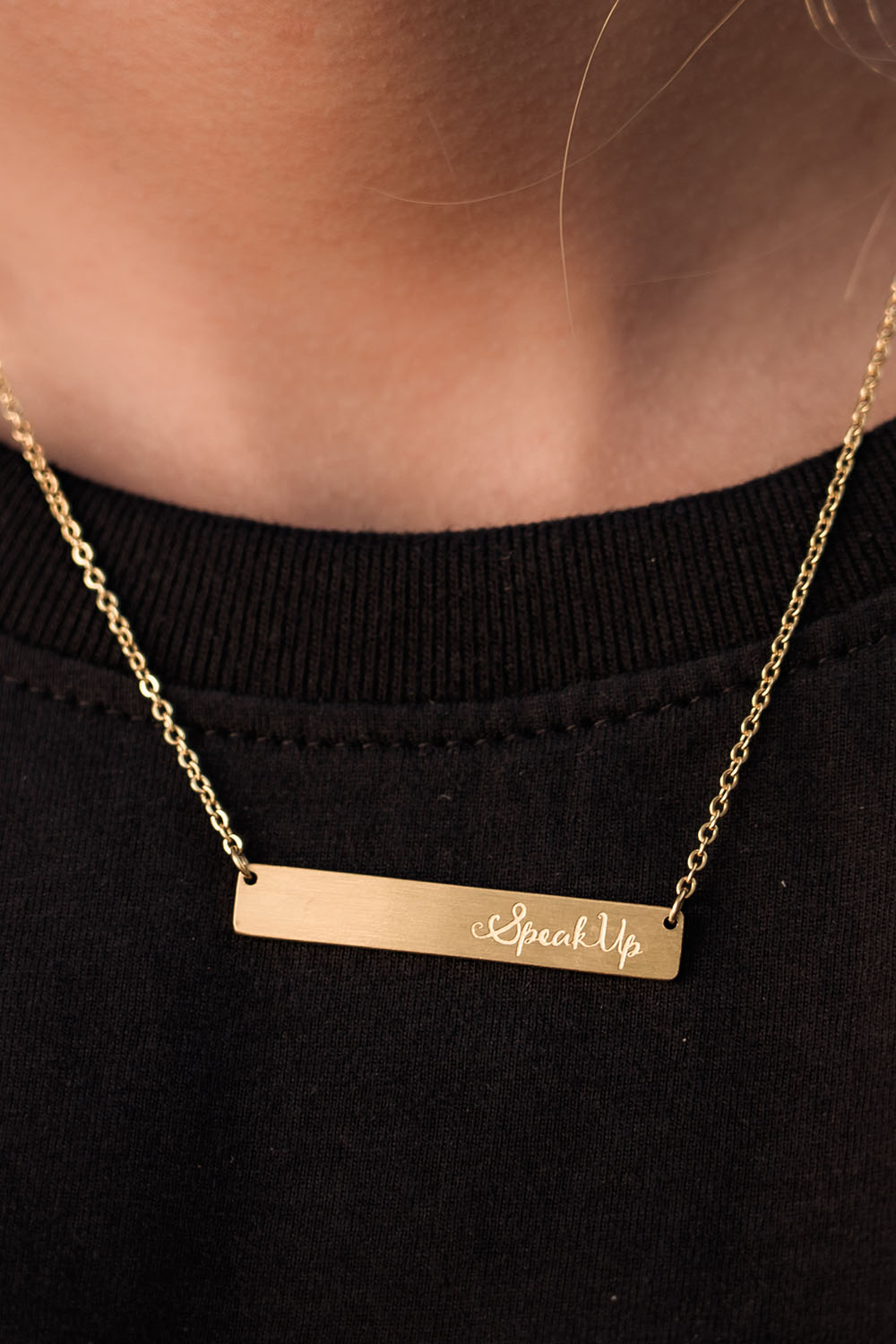 A model wearing the Speak Up Bar Necklace in colour Gold (Metallics), from the front, showing the whole outfit