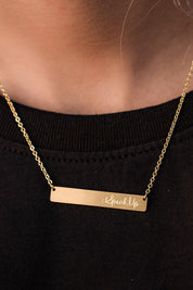 A model wearing the Speak Up Bar Necklace in colour Gold (Metallics), from the front, showing the whole outfit