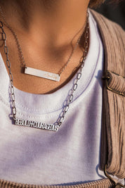 A model wearing the Speak Up Bar Necklace in colour Silver (Metallics), from the front, showing the whole outfit
