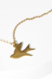 A model wearing size OneSize of the Song Of Freedom Necklace in colour Gold (Metallics), from the front, showing the whole outfit