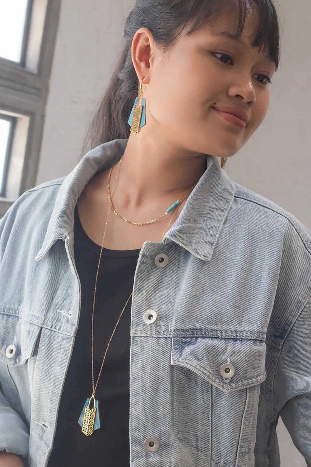 A model wearing the Parting Waters Necklace Set in colour Bluegold (Metallics), from the front, showing the whole outfit