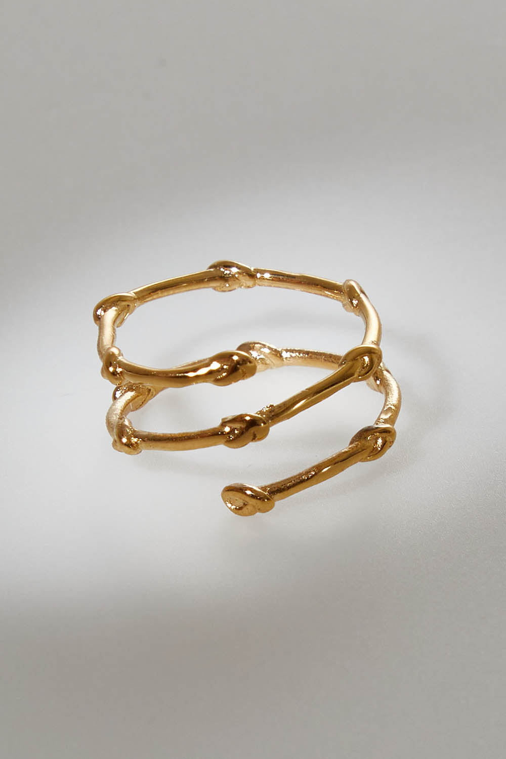 A model wearing size OneSize of the Knots Of Freedom Ring in colour Gold (Metallics), from the front, showing the whole outfit