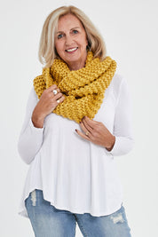 Model Sandy wearing size OneSize of the Organic Loop Scarf in colour Mustard, from the front, cropped image