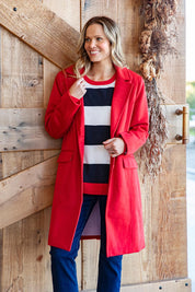 A model wearing the Tamsin Coat in colour Poppy (Red), from the front, showing the whole outfit
