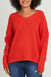 Model Olivia wearing size S of the Verity V Neck Knit in colour Tangello (Red), from the front, cropped image