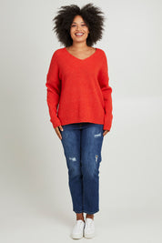 Model Olivia wearing size S of the Verity V Neck Knit in colour Tangello (Red), from the front, showing the whole outfit