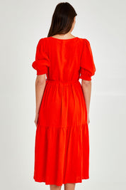 Model Madeline wearing size 10 of the Rosa Dress in colour Tangello (Red), from the back