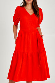 Model Madeline wearing size 10 of the Rosa Dress in colour Tangello (Red), from the front, cropped image