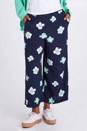 Model Olivia wearing size 10 of the Juno Floral Pant in colour Navyjuno (Blue), from the front, cropped image