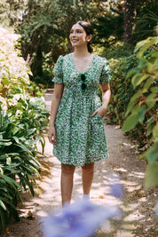 A model wearing the Prairie Floral Dress in colour Prairie (Green), from the front, showing the whole outfit