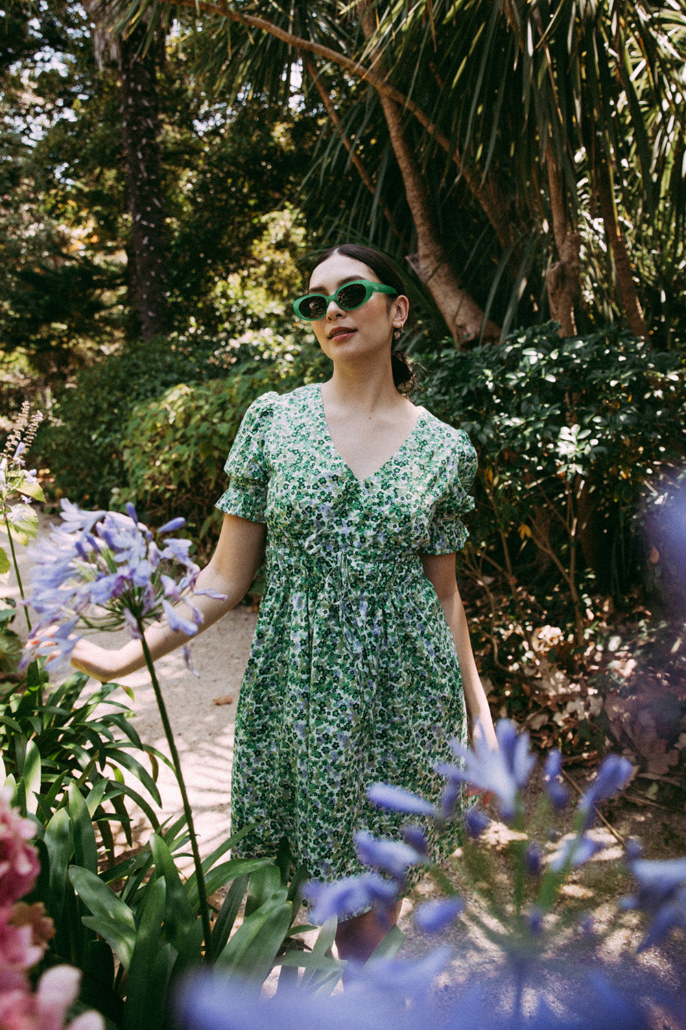 A model wearing the Prairie Floral Dress in colour Prairie (Green), from the front, showing the whole outfit