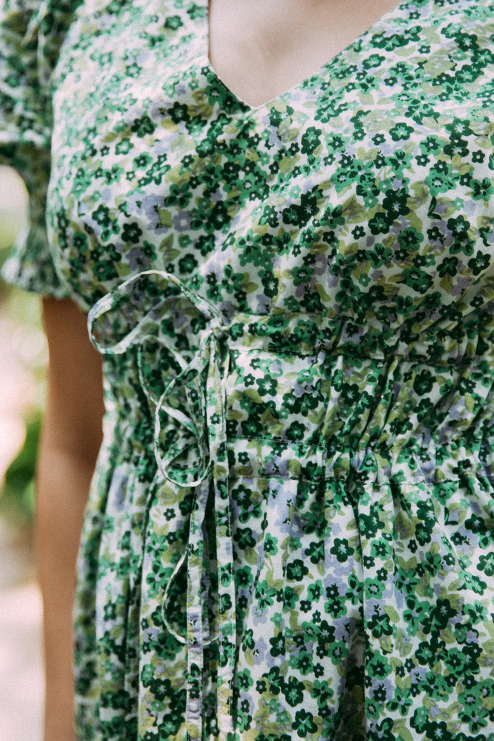 A model wearing the Prairie Floral Dress in colour Prairie (Green), from the front, showing the whole outfit