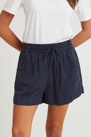 Model Madeline wearing size 10 of the Bliss Washed Short in colour Washednavy (Blue), from the front, cropped image