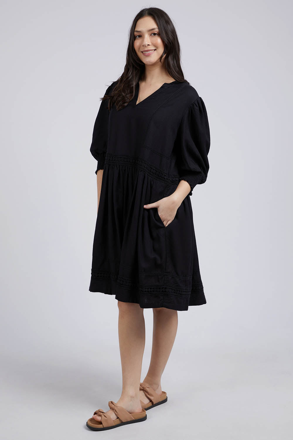 A model wearing the Market Dress in colour Black (Black), from the front, showing the whole outfit