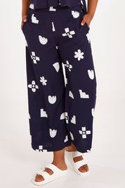 Model Olivia wearing size 10 of the Ellipse Wide Leg Pant in colour Ellipse (Blue), from the front, cropped image