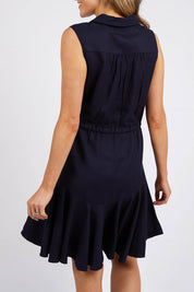 A model wearing the Clem Flippy Dress in colour Navy (Blue), from the back
