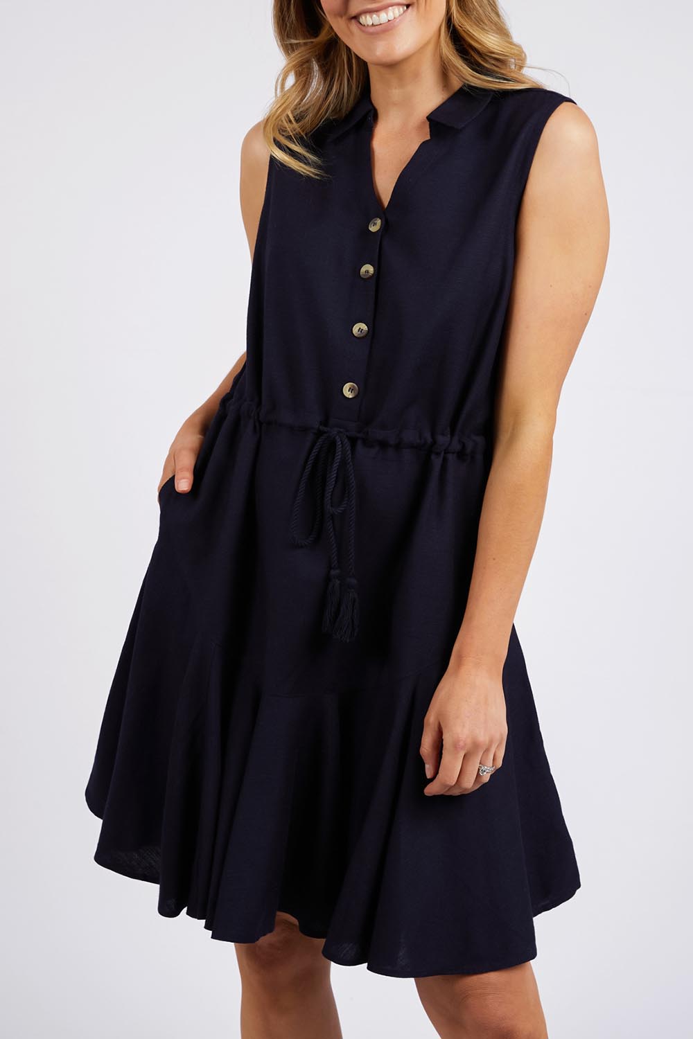 A model wearing the Clem Flippy Dress in colour Navy (Blue), from the front, cropped image
