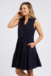 A model wearing the Clem Flippy Dress in colour Navy (Blue), from the front, cropped image