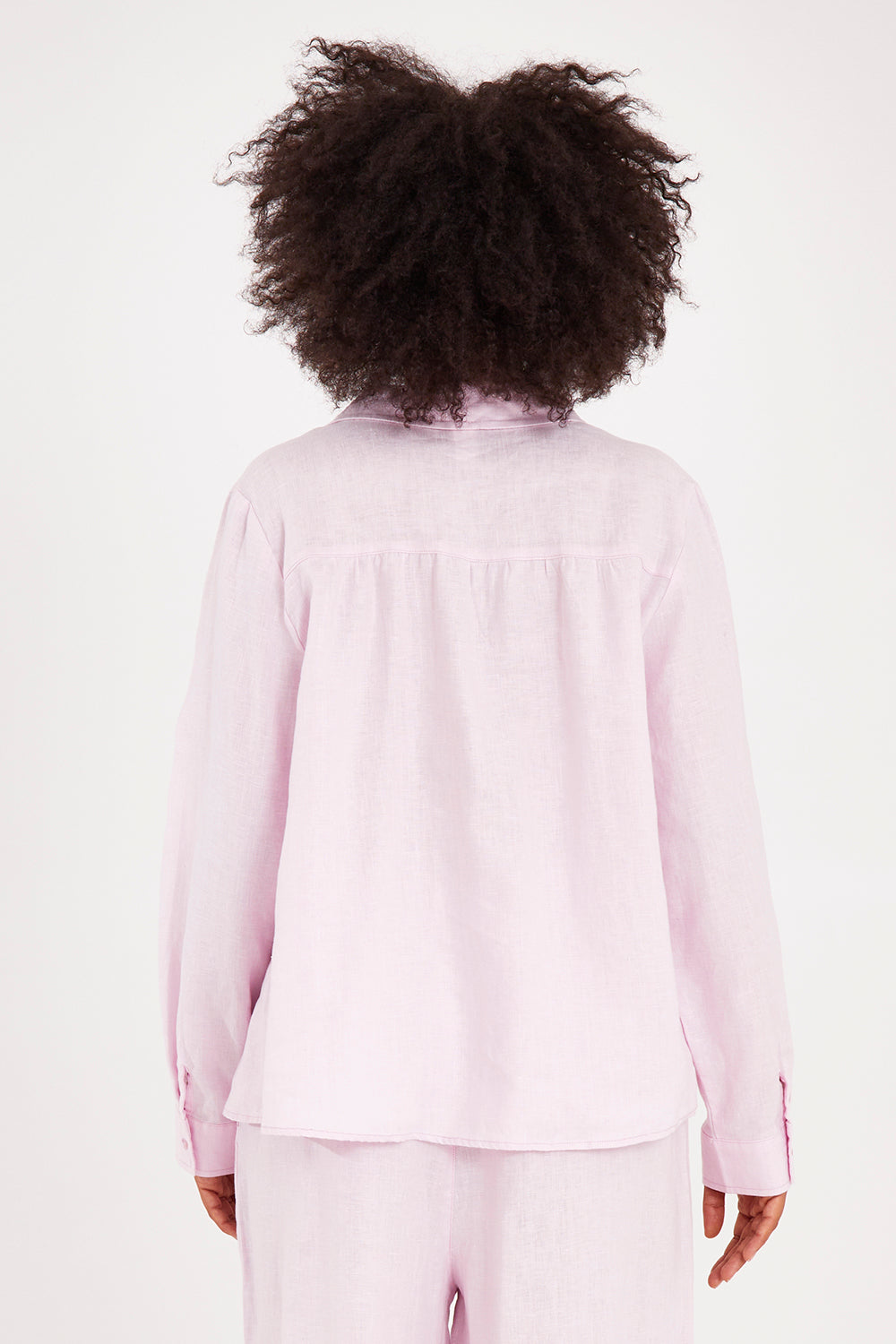 Model Olivia wearing size 10 of the Blair Open Neck Shirt in colour Blossom (Pink), from the back