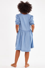 Model Olivia wearing size 10 of the Shanee Chambray Dress in colour Bluewash (Blue), from the back