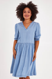 Model Olivia wearing size 10 of the Shanee Chambray Dress in colour Bluewash (Blue), from the front, cropped image