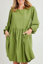Model Grace wearing size 10 of the River Dress in colour Junglegrn (Green), from the front, cropped image