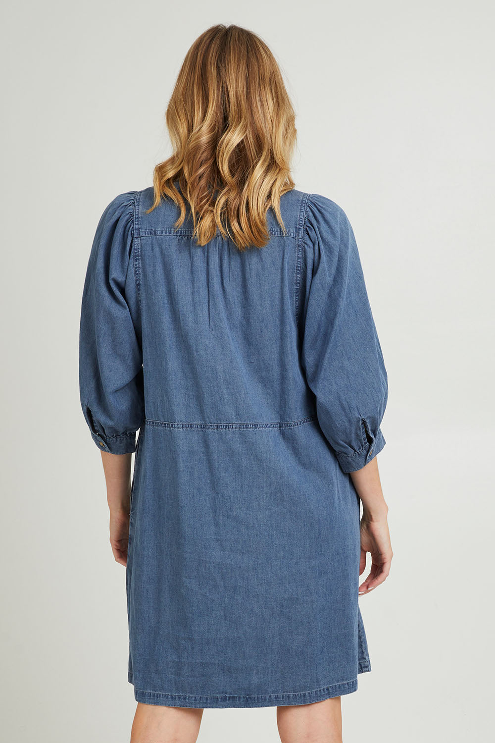 Model Grace wearing size 10 of the Filippa Dress in colour Midblue (Blue), from the back
