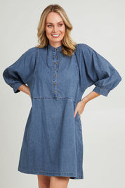 Model Grace wearing size 10 of the Filippa Dress in colour Midblue (Blue), from the front, cropped image