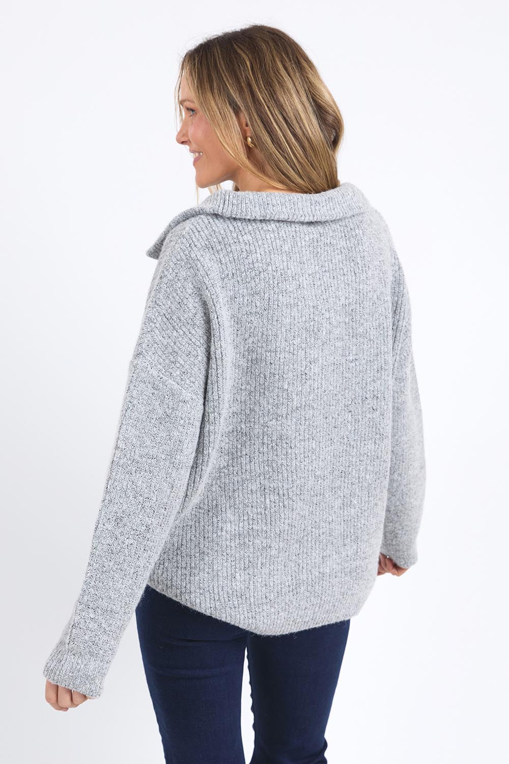 A model wearing the Bron Button Knit in colour Greymarle (Grey), from the back