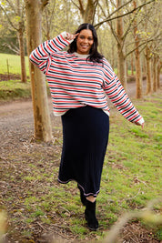 A model wearing the Rye Stripe Knit in colour Peonypink (Pink), from the front, showing the whole outfit