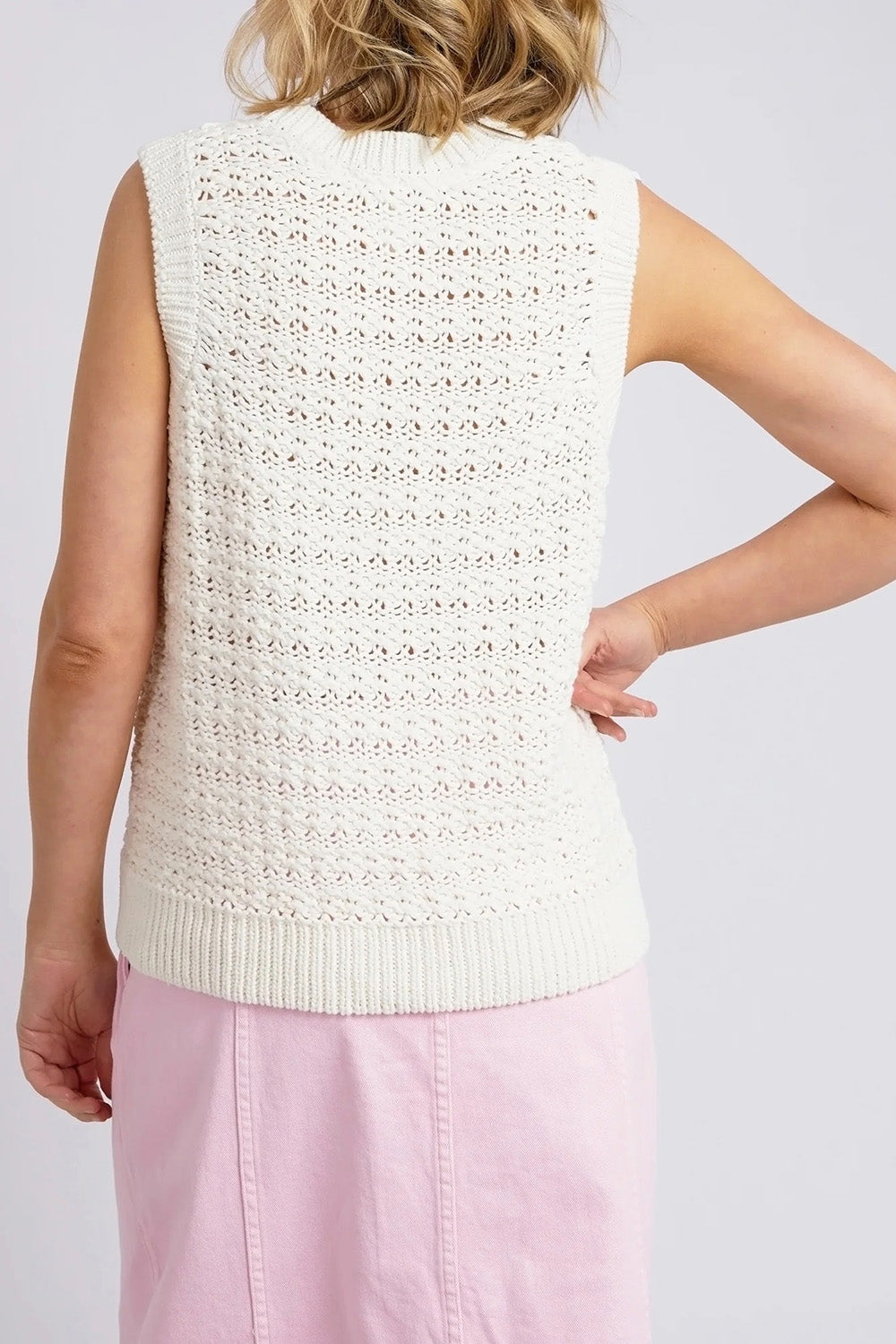 A model wearing the Janey Knit Vest in colour Pearl (White), from the back