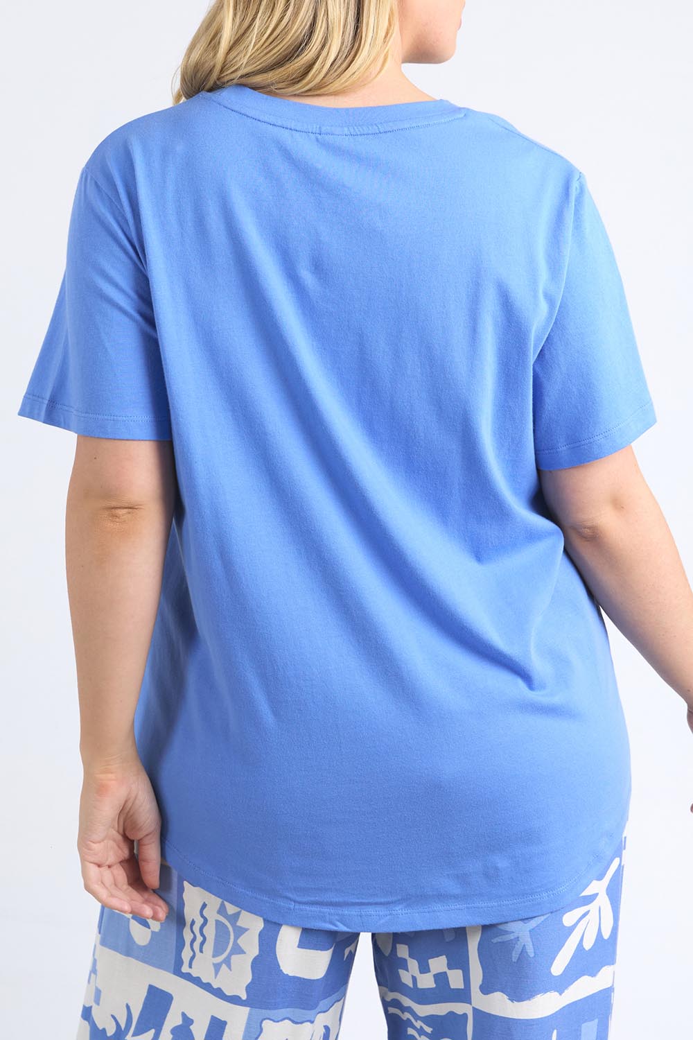 A model wearing the Holiday Sun Tee in colour Cerulean (Blue), from the back