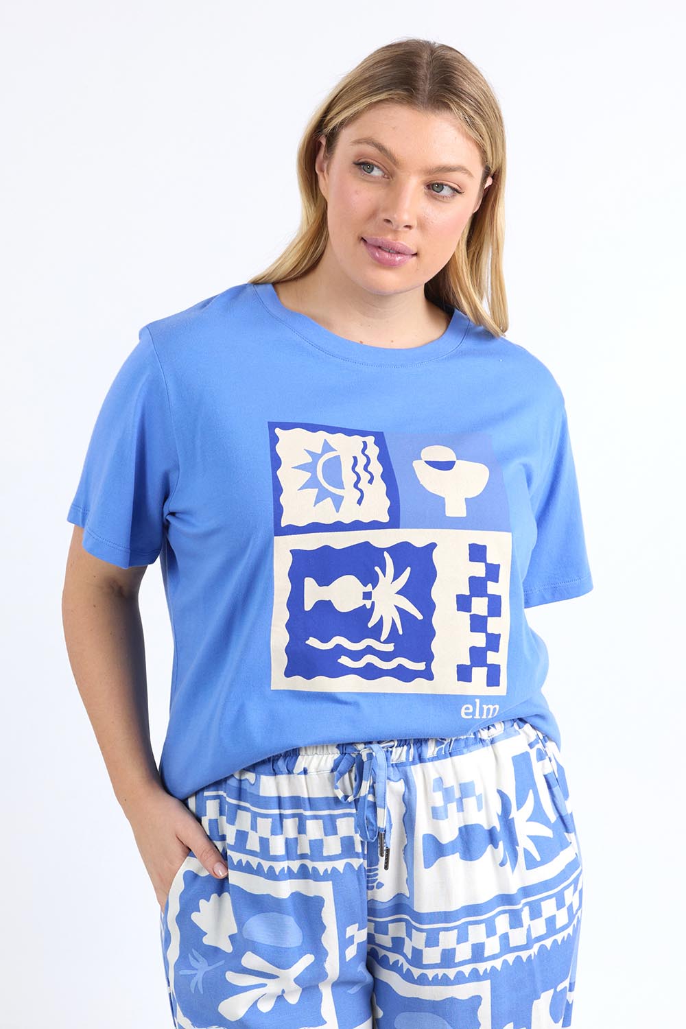 A model wearing the Holiday Sun Tee in colour Cerulean (Blue), from the front, cropped image