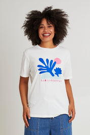 Model Olivia wearing size 10 of the Art House Cotton Tee in colour Marshmello (White), from the front, cropped image