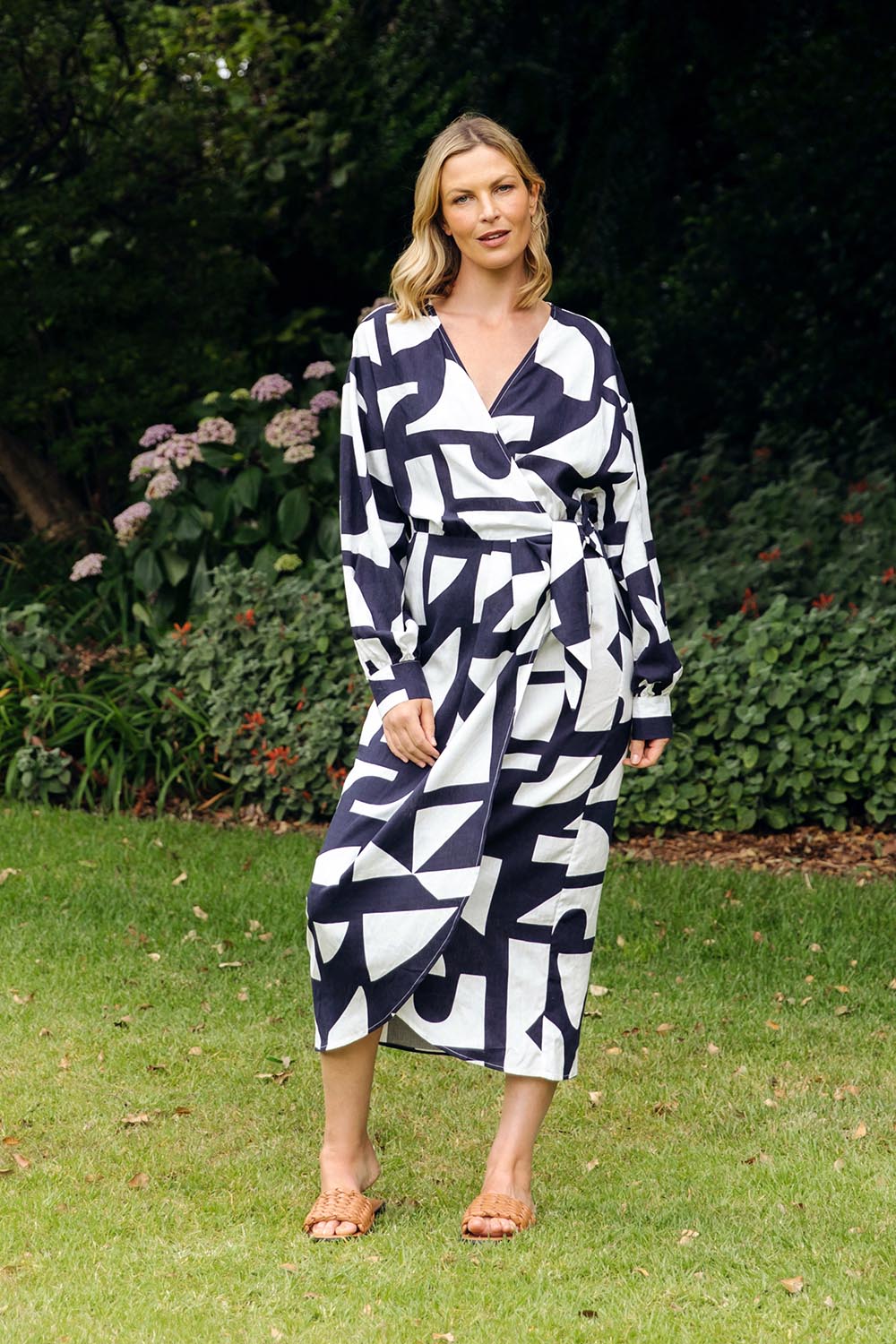 A model wearing the Dali Abstract Dress in colour Midnight (Blue), from the front, showing the whole outfit