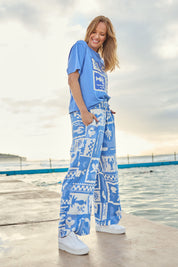 Model Katie wearing size 10 of the Holiday Sun Pant in colour Cerulean (Blue), from the front, showing the whole outfit
