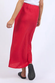 A model wearing the Eleni Linen Skirt in colour Bitterswee (Red), from the back