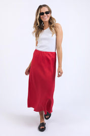 A model wearing the Eleni Linen Skirt in colour Bitterswee (Red), from the front, showing the whole outfit