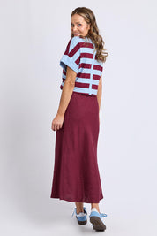 A model wearing the Eleni Linen Skirt in colour Plum (Red), from the back