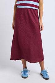A model wearing the Eleni Linen Skirt in colour Plum (Red), from the front, cropped image