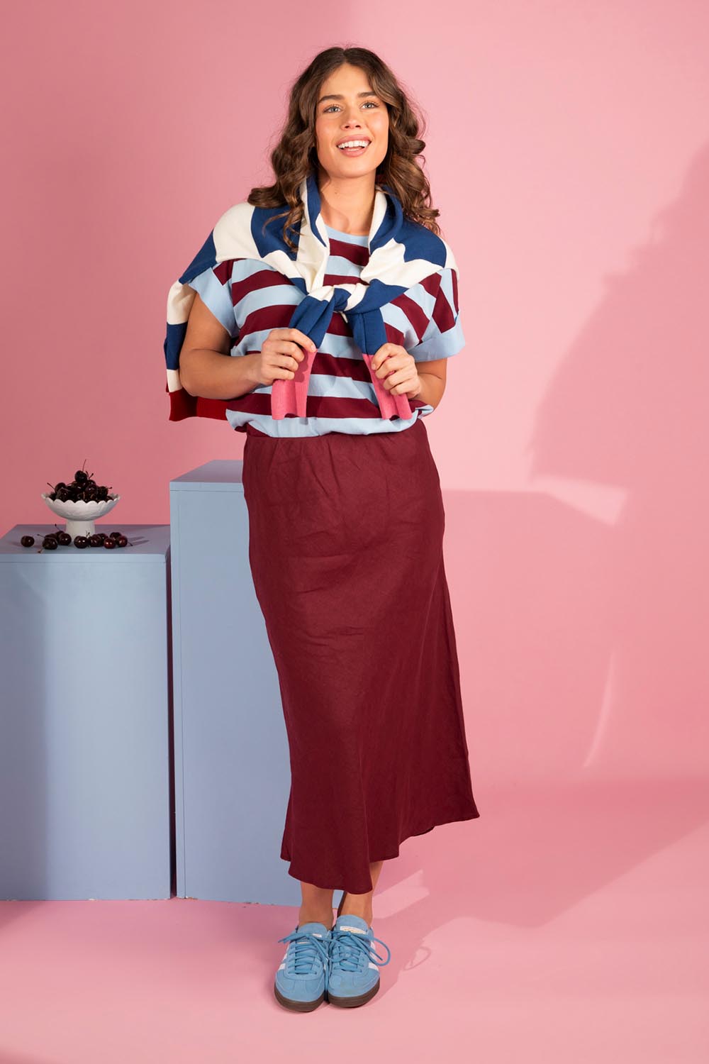 A model wearing the Eleni Linen Skirt in colour Plum (Red), from the front, showing the whole outfit