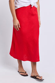 A model wearing the Eleni Linen Skirt in colour Poppy (Red), from the front, cropped image