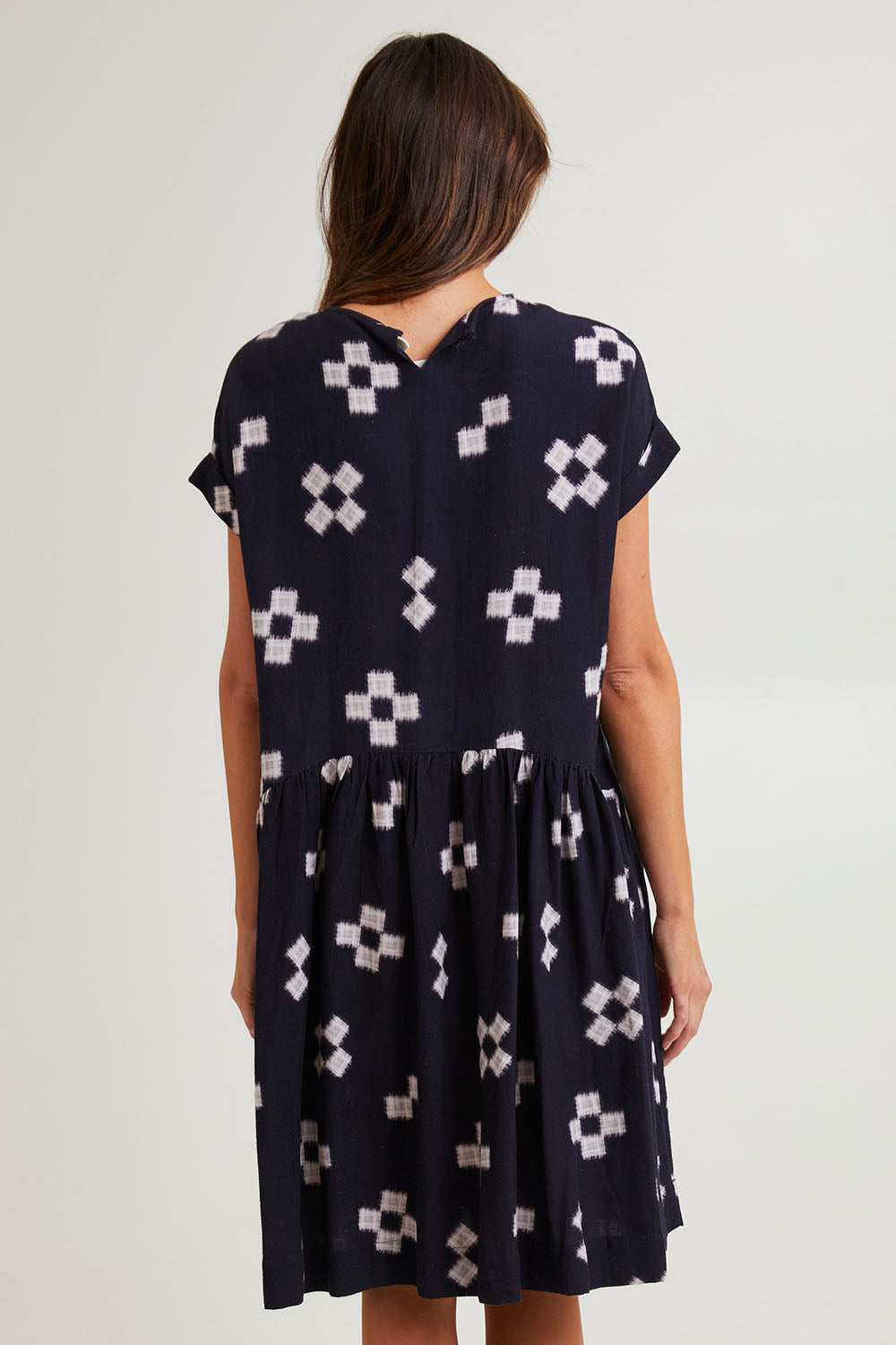 Model Madeline wearing size 10 of the Positano Linen Blend Dress in colour Navyprint (Blue), from the back