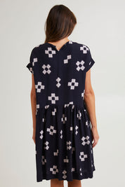 Model Madeline wearing size 10 of the Positano Linen Blend Dress in colour Navyprint (Blue), from the back